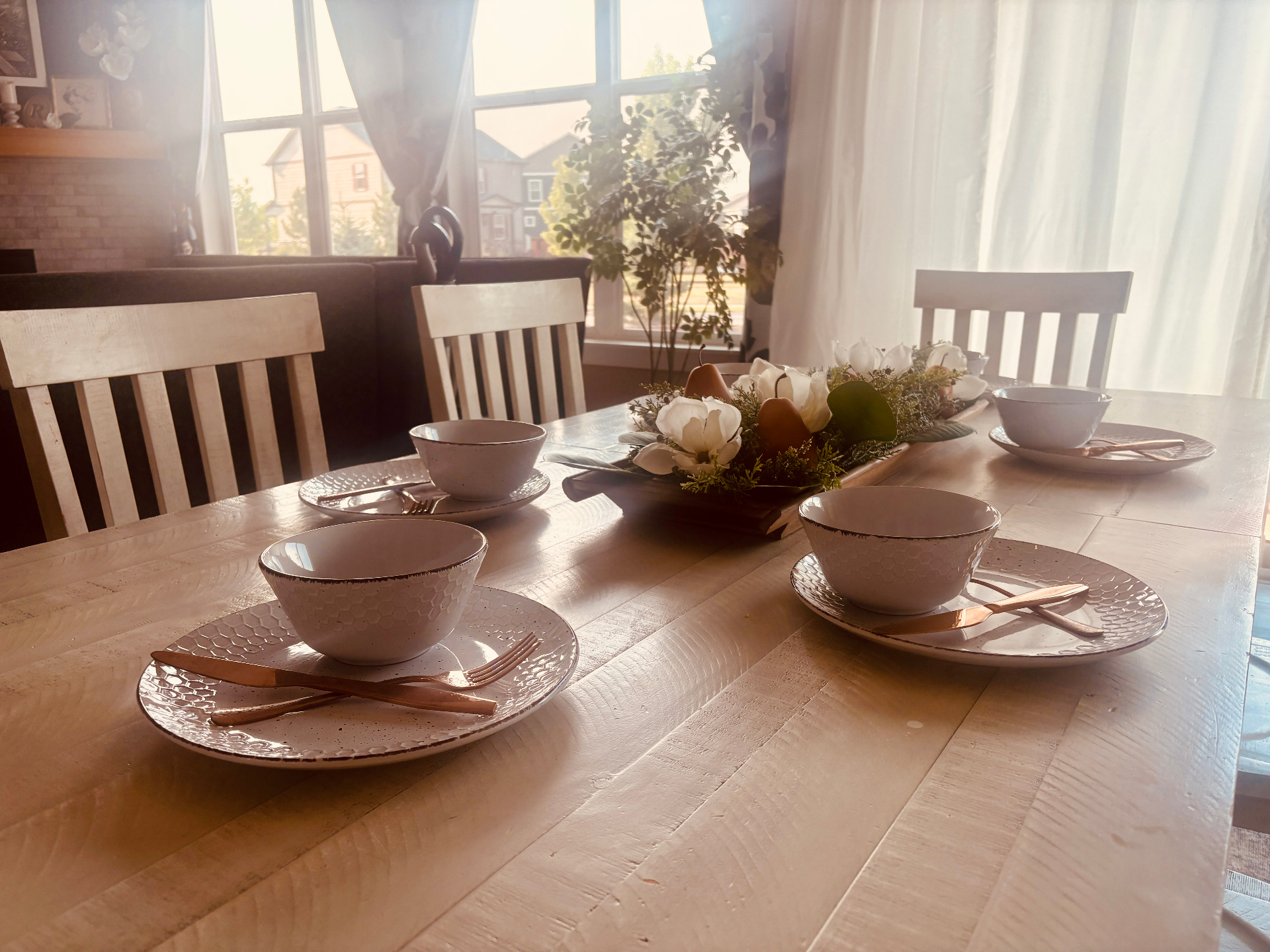 Sunlit private dining table set with ceramic bowls and fresh flowers